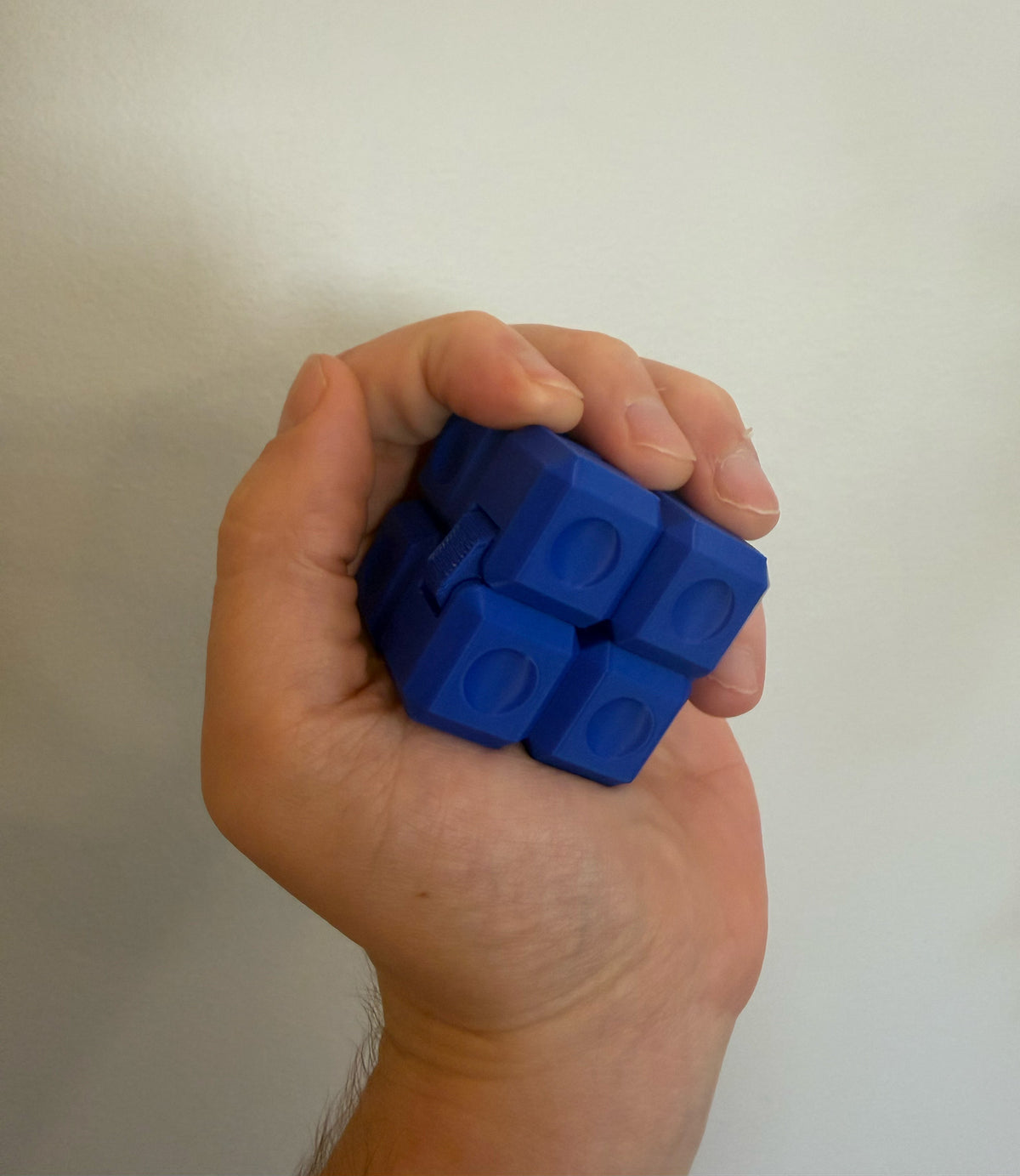 Blue 3D printed Infinity Cube fidget toy folded into a cube and held in one hand
