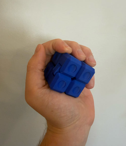 Blue 3D printed Infinity Cube fidget toy folded into a cube and held in one hand
