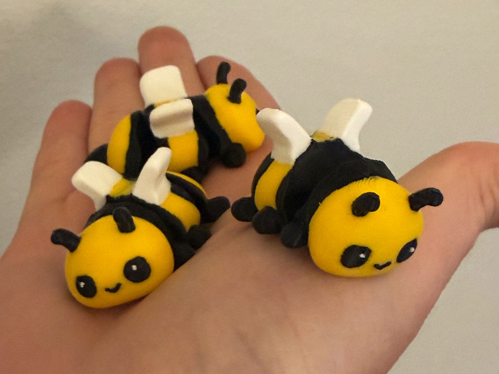 Three Mini Flexi Bumblebees held in an open hand to show their small size