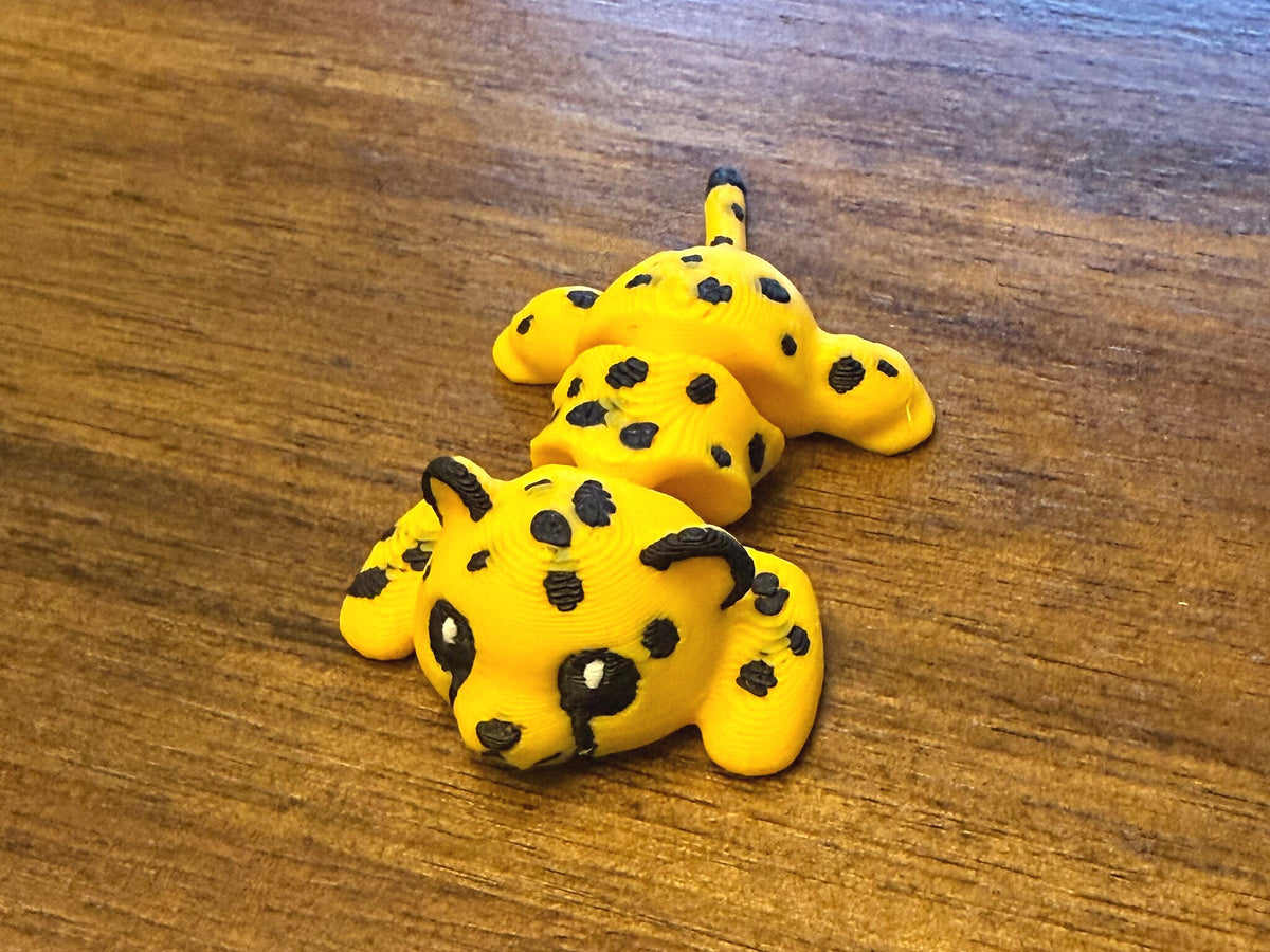 Close-up of a single yellow flexi cheetah cub with black spots, three-quarter view