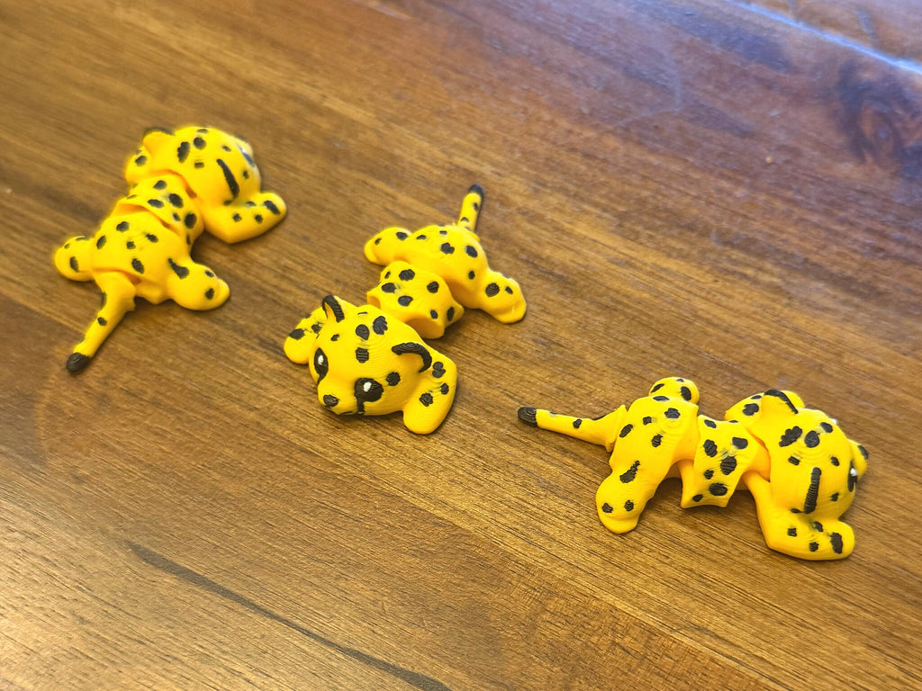 Three flexi cheetahs on a table shown from multiple angles