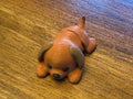 Brown 3D printed Mini Flexi Dog puppy with floppy ears and a black nose, three-quarter front view on a wood table