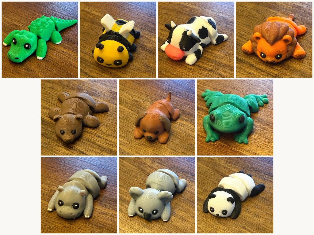 Ten assorted 3D printed Mini Flexi Animals from Grey Duck Labs laid out in a grid: alligator, bumblebee, cow, lion, bear, dog, frog, hippo, koala, and panda
