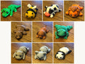 Ten assorted 3D printed Mini Flexi Animals from Grey Duck Labs laid out in a grid: alligator, bumblebee, cow, lion, bear, dog, frog, hippo, koala, and panda