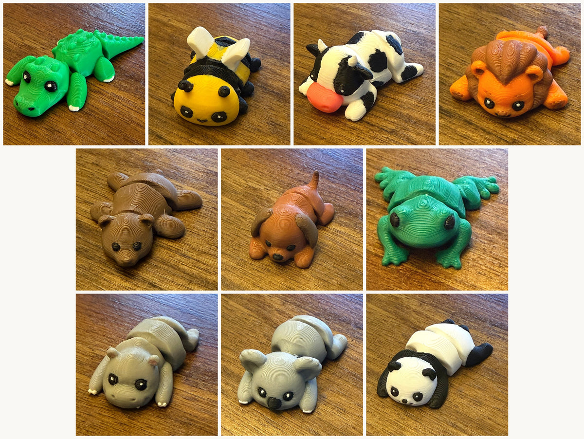 Ten assorted 3D printed Mini Flexi Animals from Grey Duck Labs laid out in a grid: alligator, bumblebee, cow, lion, bear, dog, frog, hippo, koala, and panda