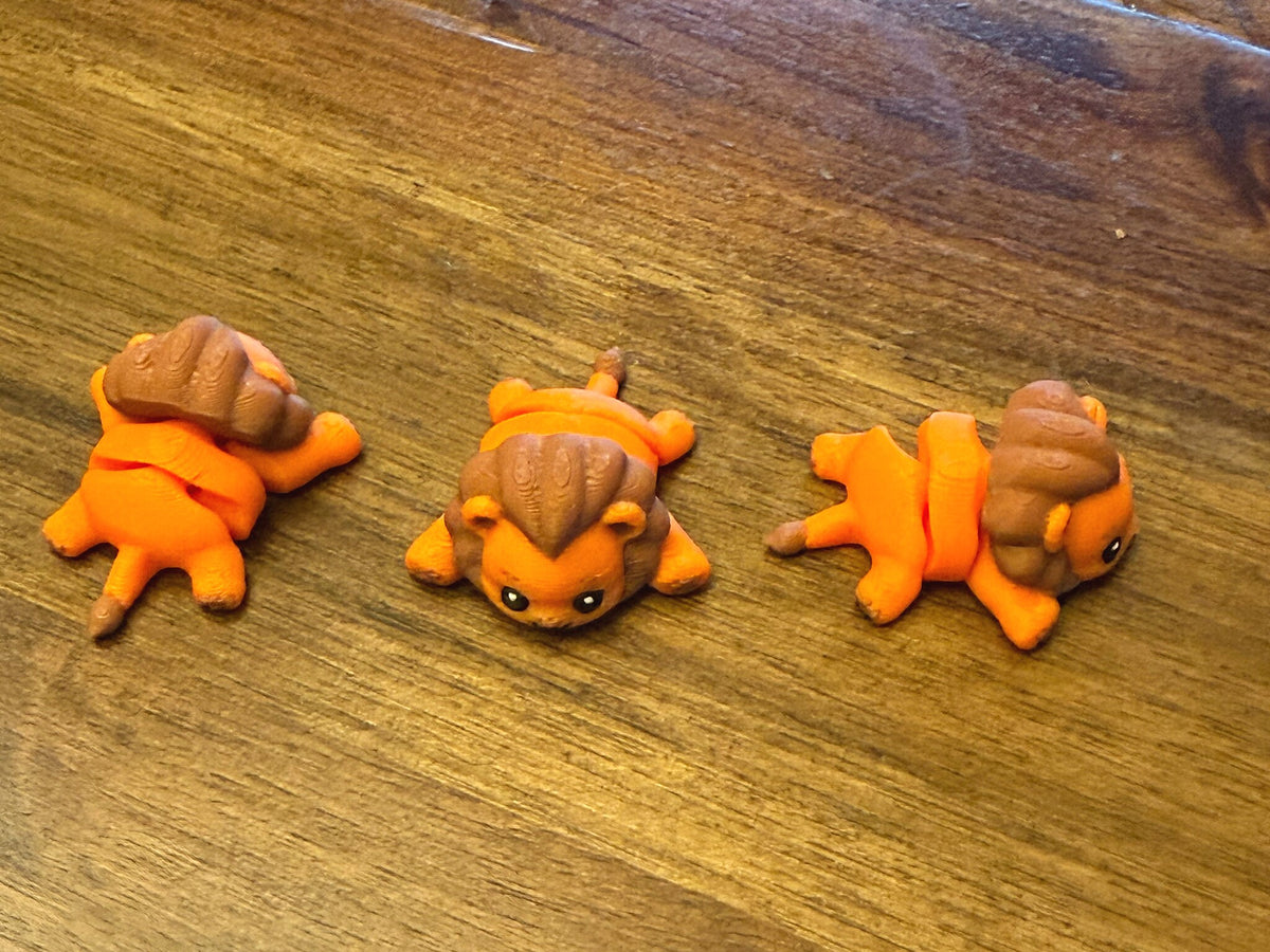 Three flexi lions on a table shown from the top and side