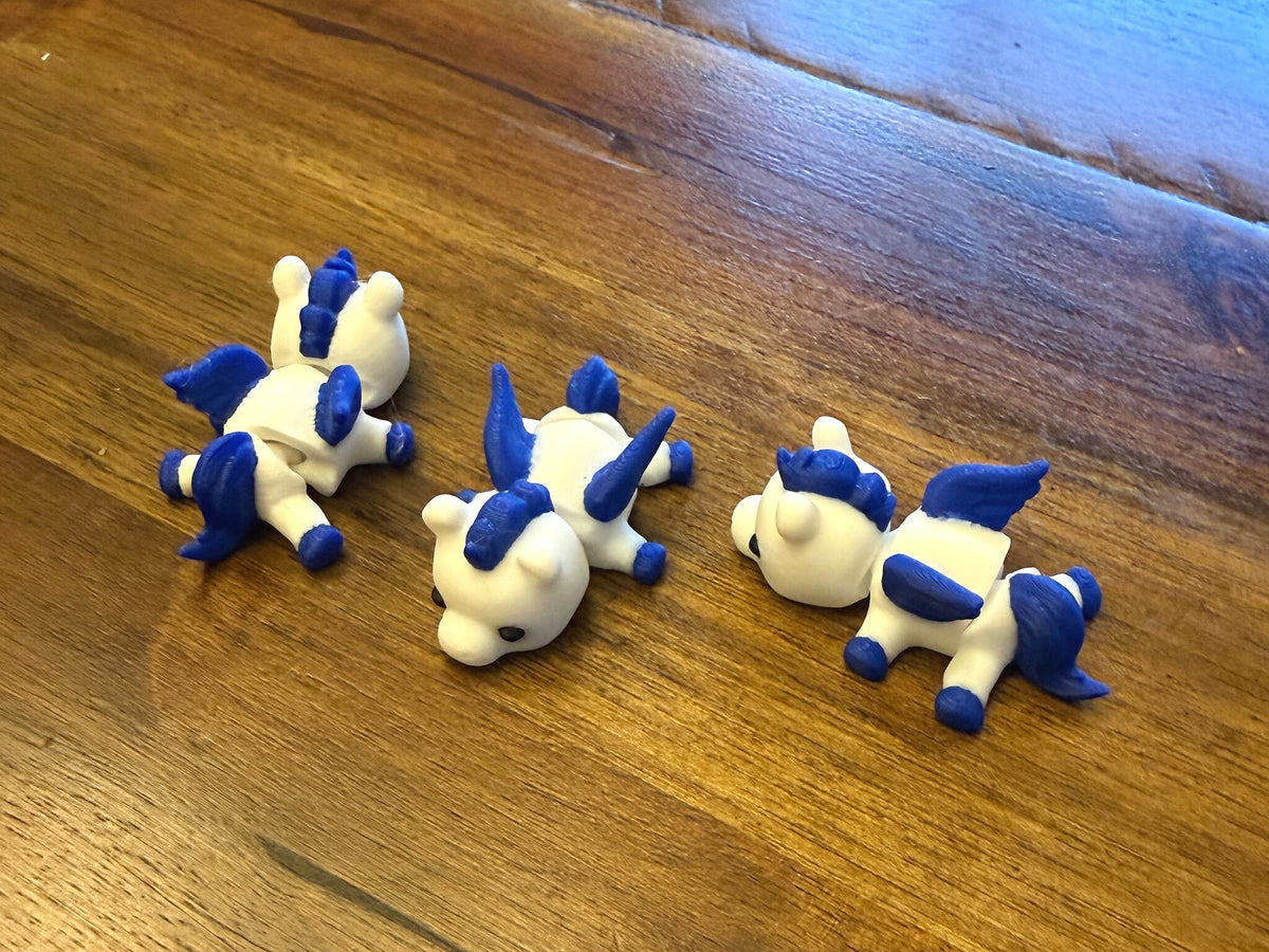 Three Mini Pegasus figurines arranged on a table