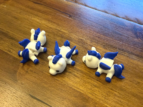 Three Mini Pegasus figurines arranged on a table