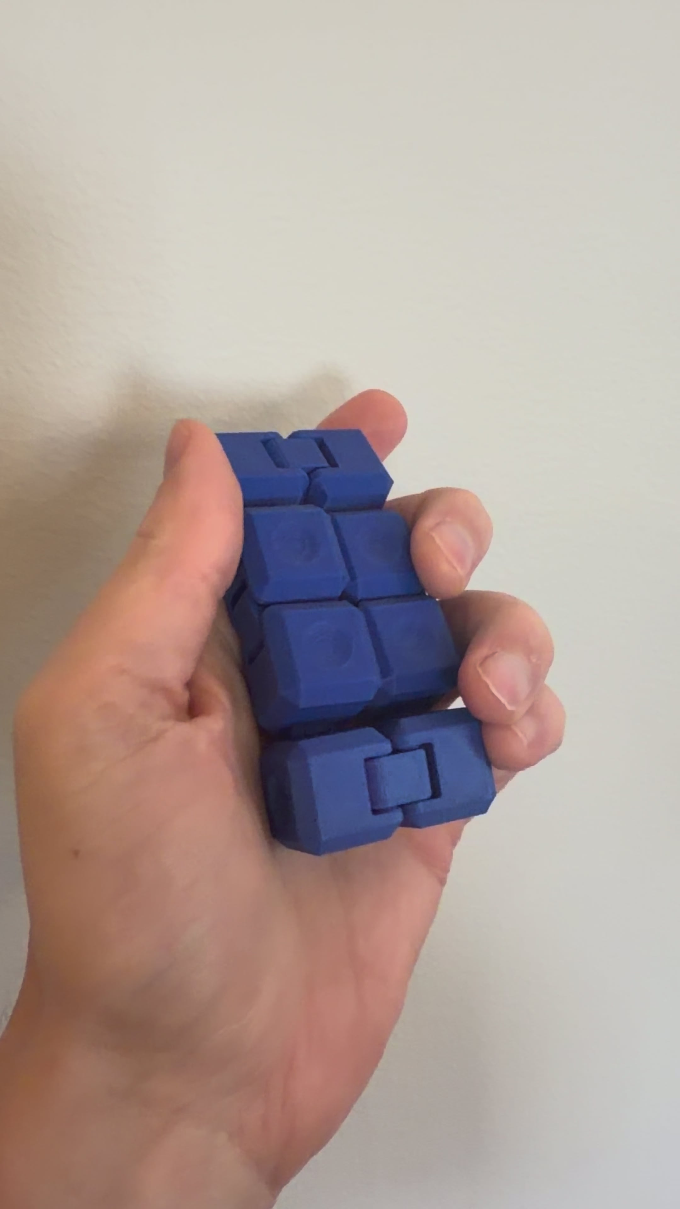 Video of a blue Infinity Cube fidget toy being folded and flipped in one hand
