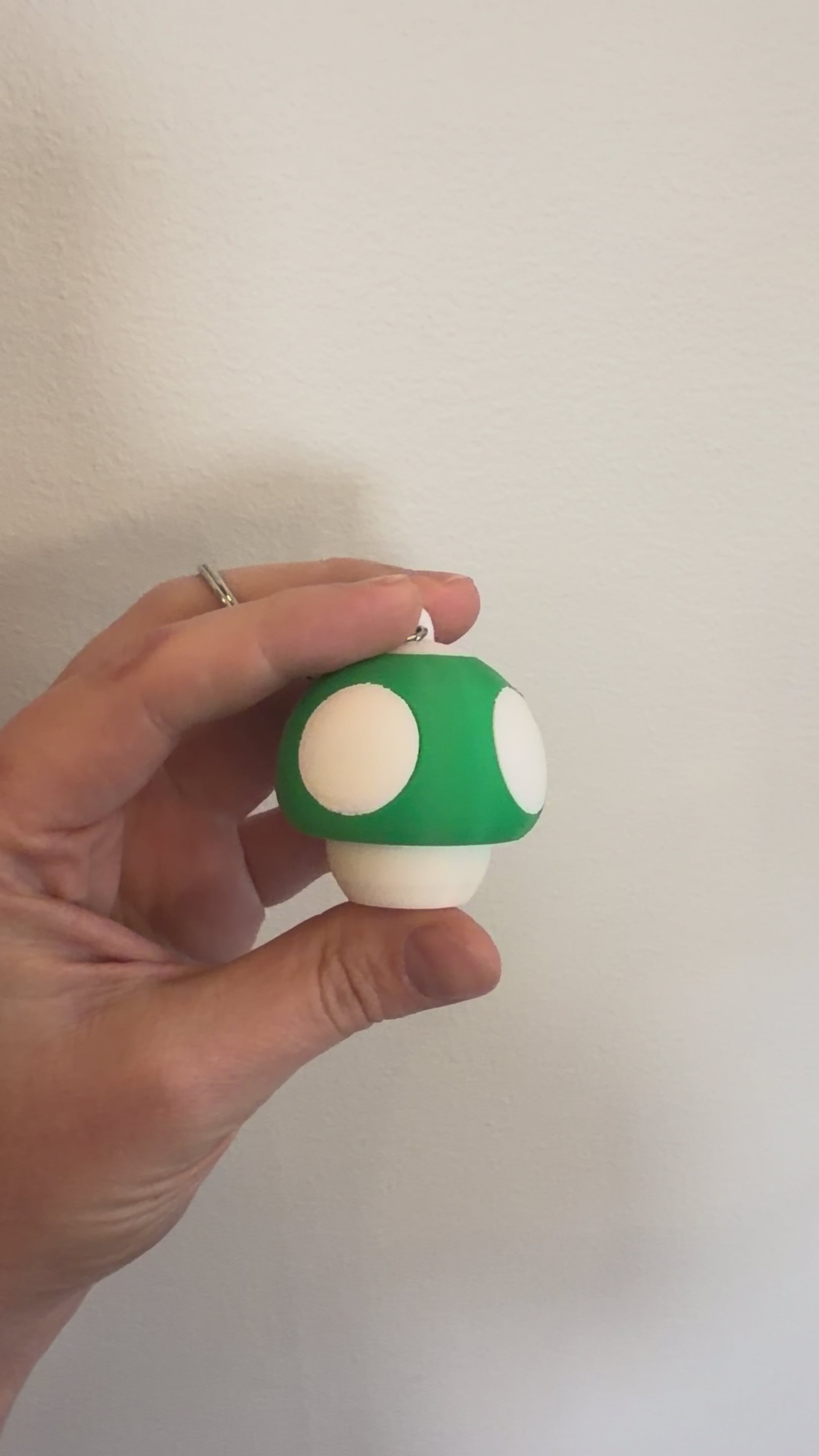 Video of the green Mushroom Clicker Keychain being clicked between finger and thumb
