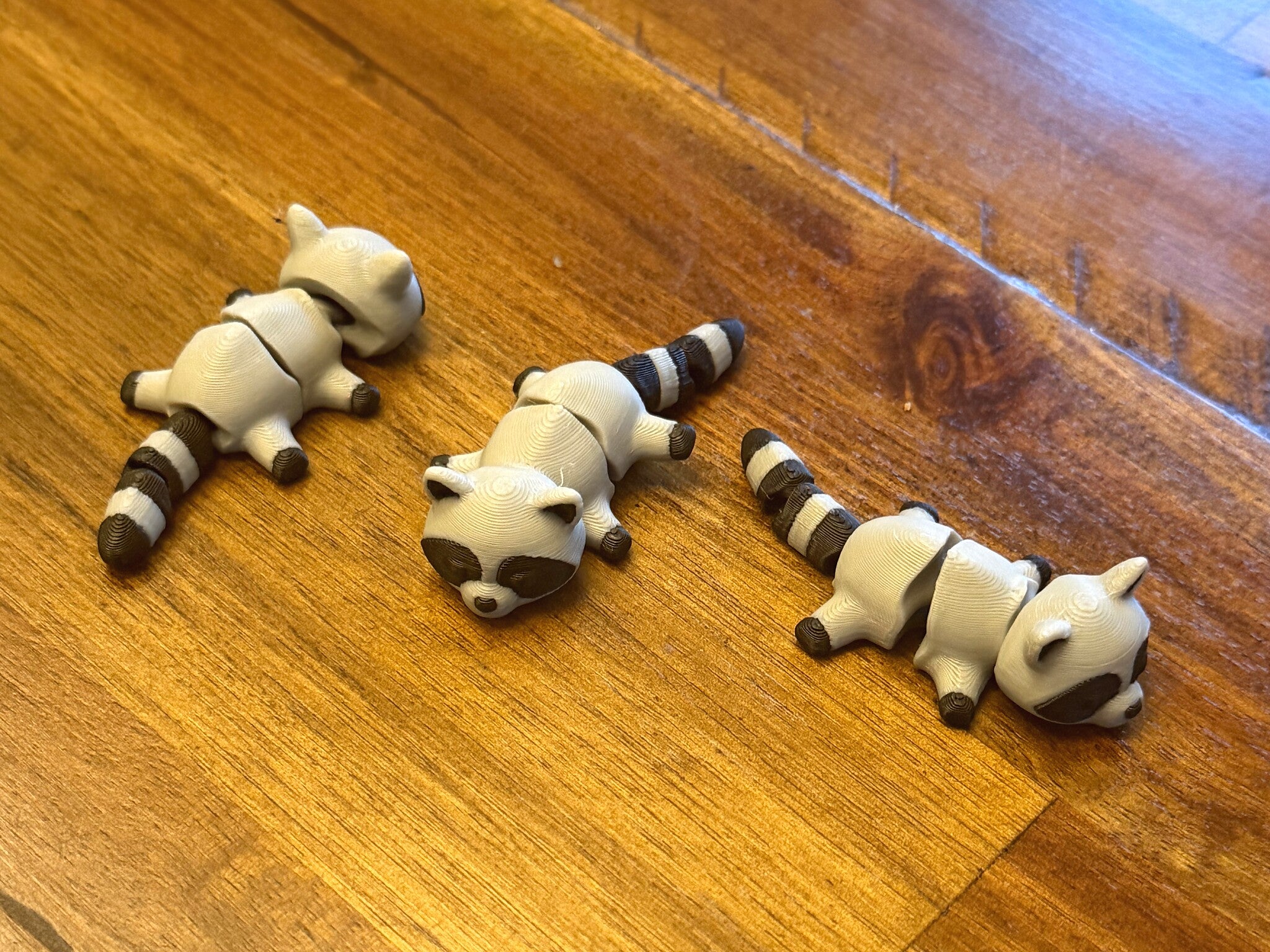 Three flexi raccoons shown from multiple angles